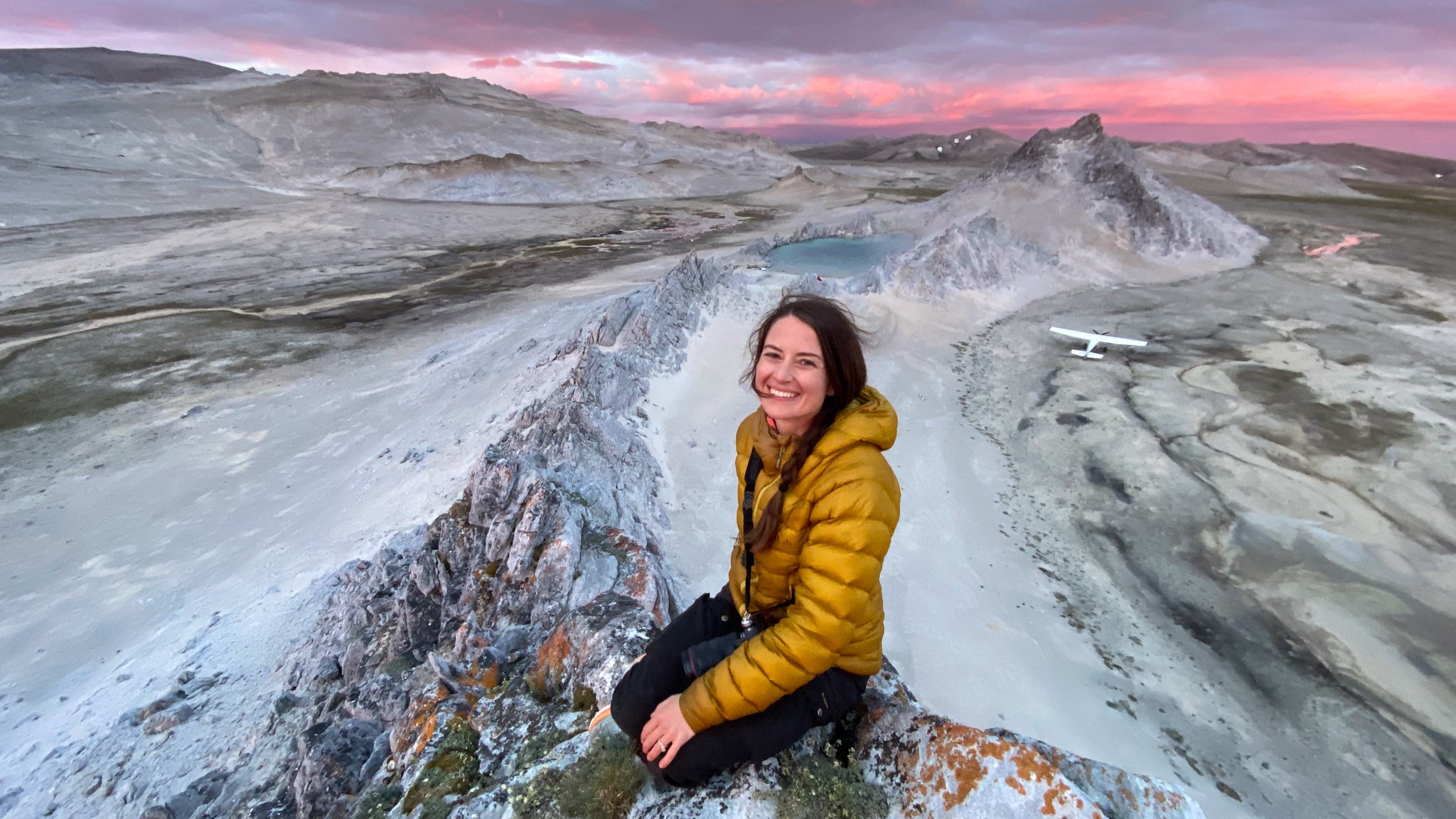 Woman sitting on rock in mountainous area